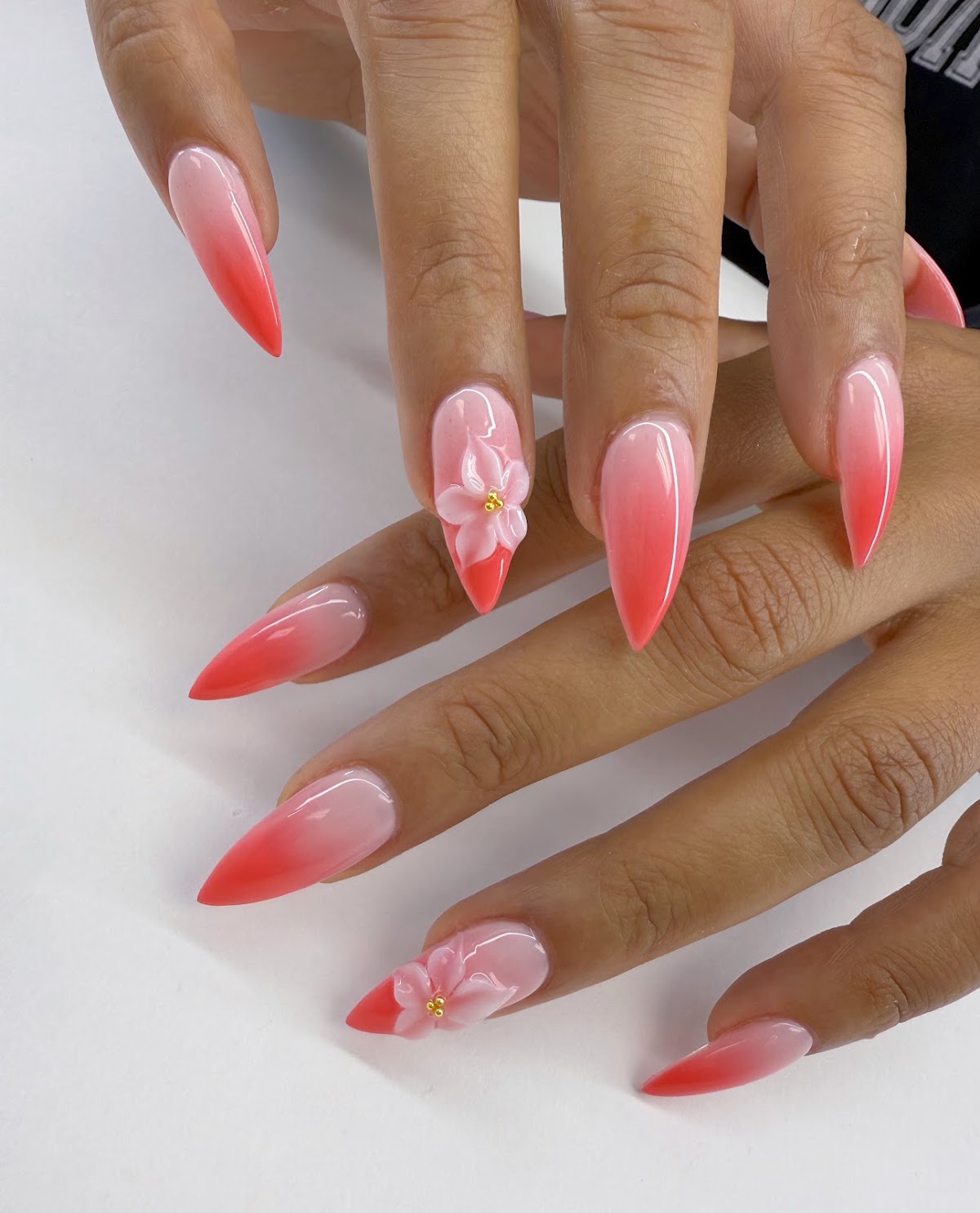 Coral ombre stiletto nails with sculpted three dimensional blossoms