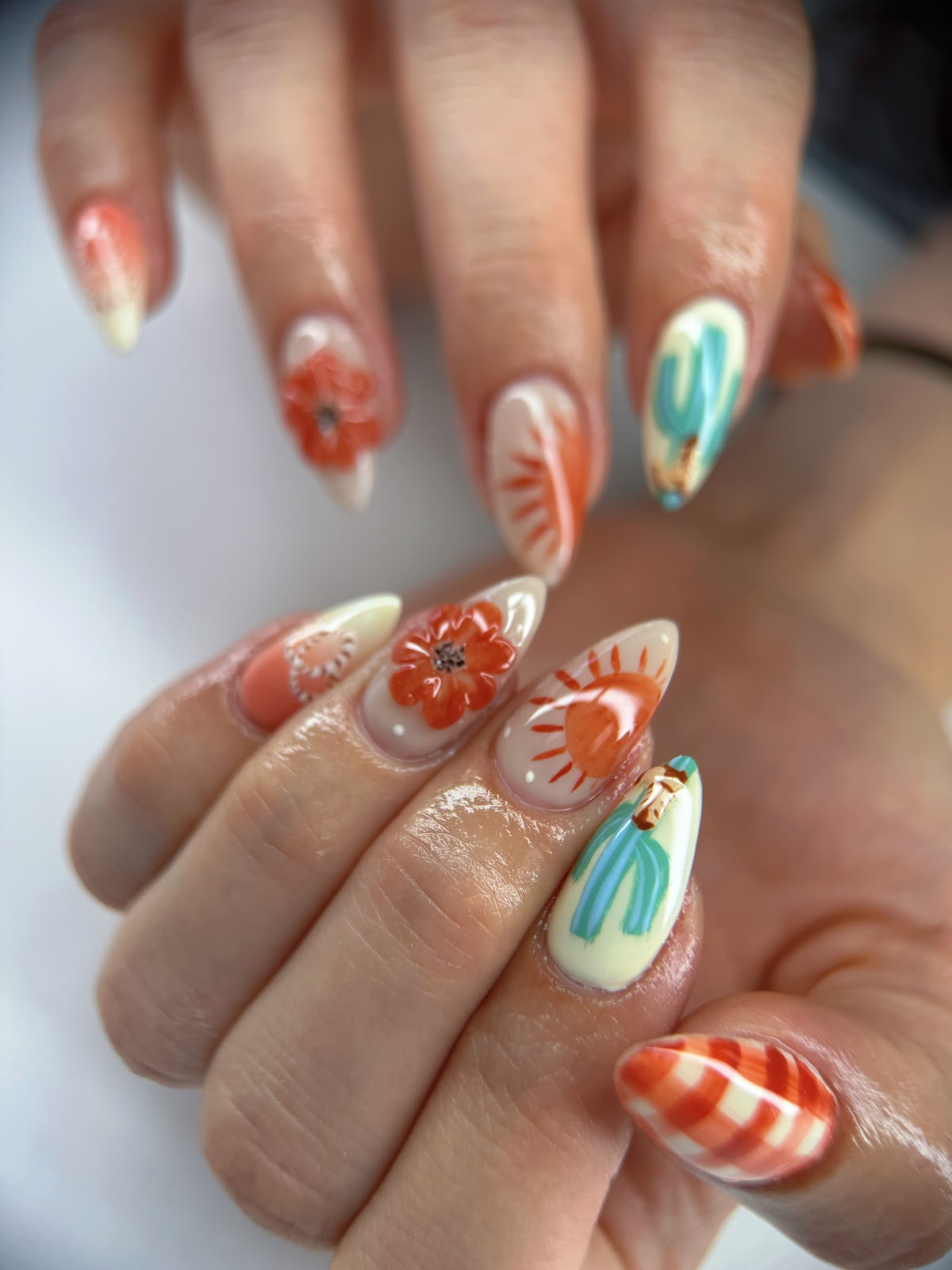 Hand painted desert nail art with poppies, sunbursts and cacti in terracotta and sage