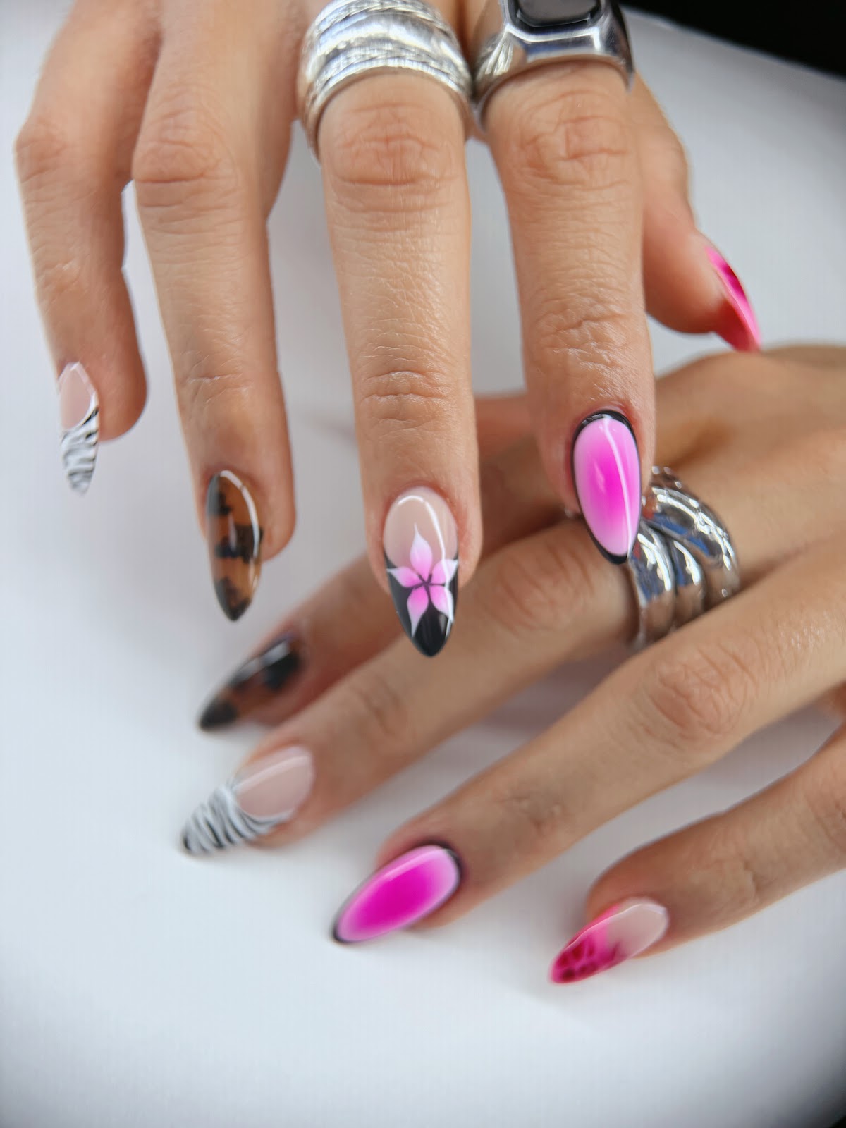 Airbrushed pink and black nails with zebra tips and tortoiseshell