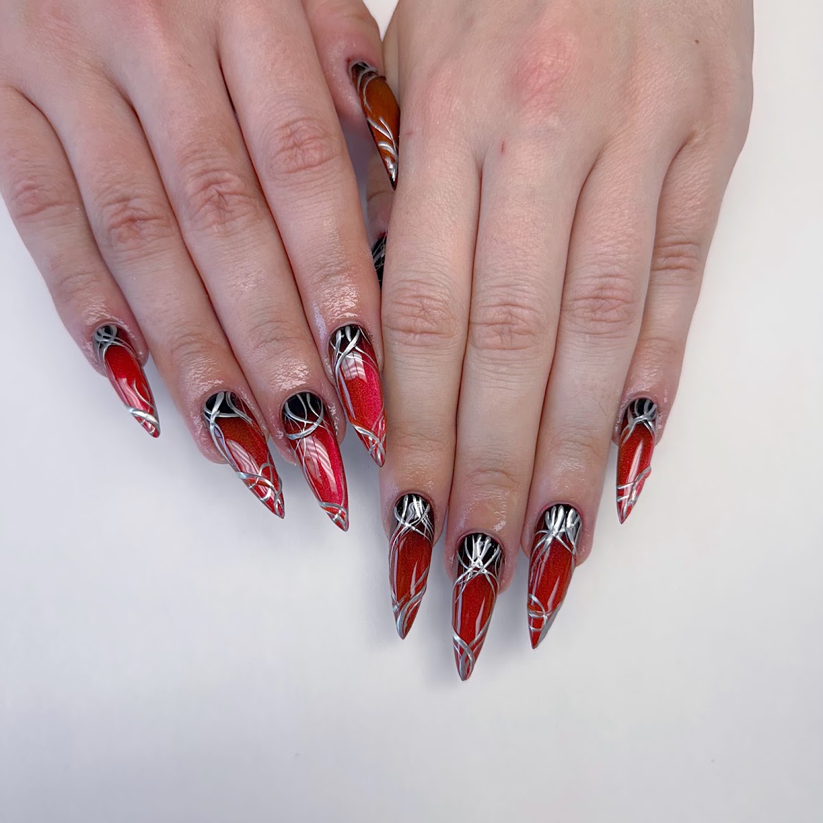Deep red shimmer nails with a silver chrome swirl